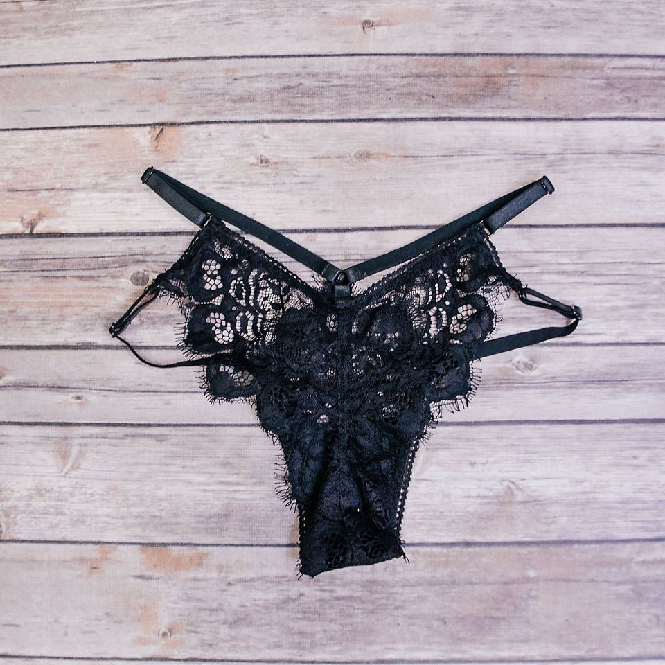 Black delicate lace underwear with adjustable straps and high rise.